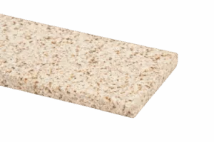 Zbliżenie na beżowy, nakrapiany parapet granitowy z zaokrągloną krawędzią na neutralnym tle.