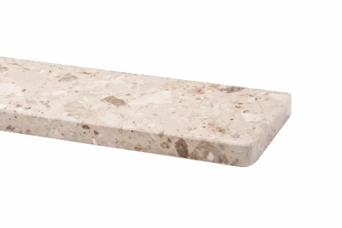 Zbliżenie na beżowy parapet marmurowy Breccia Aurora z widocznym kruszywem i zaokrągloną krawędzią.