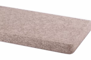 Prostokątny parapet z jasnoszarego marmuru o ziarnistej fakturze i zaokrąglonej krawędzi, widok z boku.