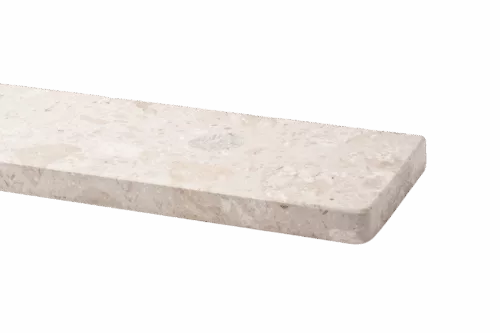 Kremowy, marmurowy parapet z zaokrągloną krawędzią i drobnym, nakrapianym wzorem na jednolitym tle.